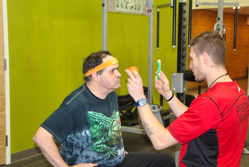 Brow Brow and Spencer Morse, performing some focus drills to help Brow train his eyesight at the Goodlife Fitness gym in Antigonish.