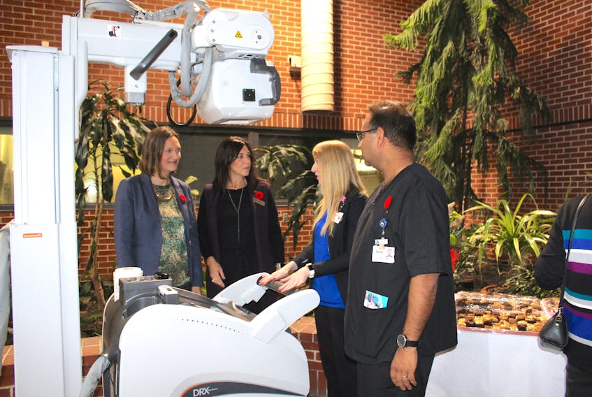 Earle Ali, right, and Courtney Smith, medical radiation technologists at the Sackville Memorial Hospital, talk about the benefits of the new mobile digital x-ray unit to Memramcook-Tantramar MLA Megan Mitton, left, and foundation board member Cindy Crossman during Thursday’s donor recognition event.