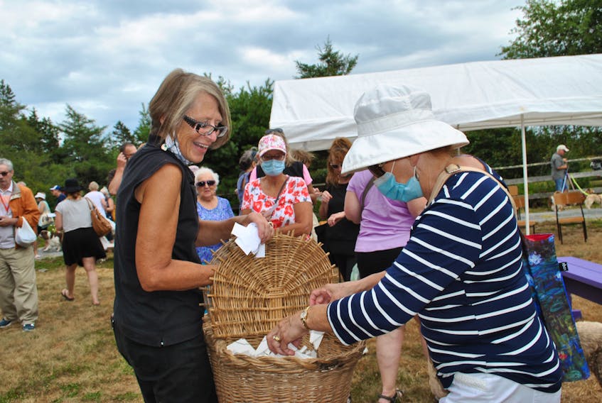 Ardra Cole (left), founder of ElderDog Canada gives out butterflies to be released in memory or in honour of canine companions at the ElderDog butterfly release in Lunenburg County on Aug. 15.