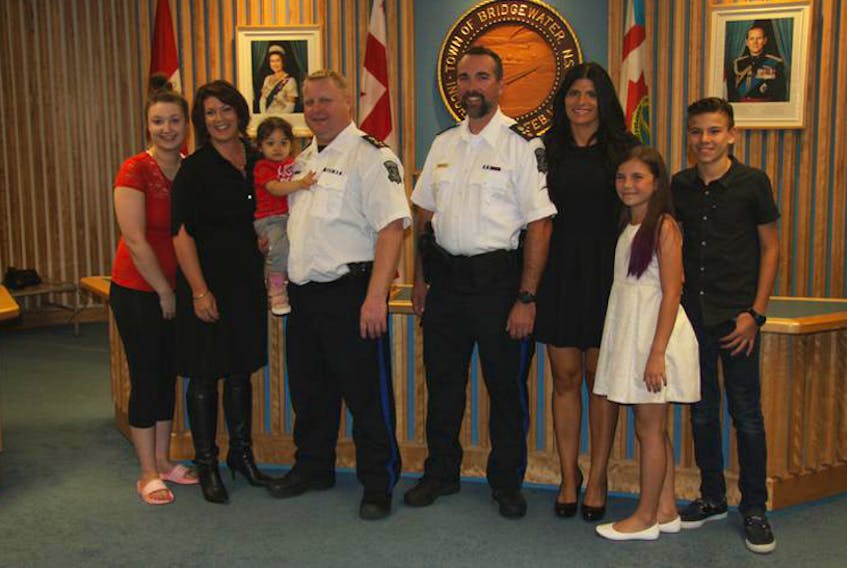 Newly sworn in police chief Scott Feener (left) and deputy police chief Danny MacPhee pose for a photograph with their families following the official Bridgewater Police Commission rank change ceremony at Bridgewater Town Hall on Oct. 4.