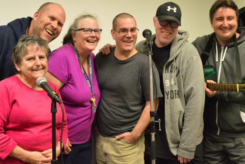 Members of the Island Media Arts Cooperative mental health stand-up comedy group, from left, Margie MacGillivary, Dave Hicks, Madge Mossberg, Ryan Gallant, Brenlae MacMillan and Andrew Campbell yuck it up at the microphones while rehearsing for their event this Sunday at The Guild.  SUBMITTED PHOTO