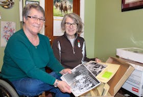 Joanne MacDonald (left) and Mary Reid (right) are long-time advocates who are working to fill an emptiness in the province’s archives with a collection of materials about the history of disability and disability rights. MacDonald holds a photograph of the Queen Mother meeting children who used wheelchairs during her Canadian Centennial visit to St. John’s. Reid holds a photo of a child at Sunshine Camp when it was a rehabilitation centre for children with physical disabilities due to polio. -JUANITA MERCER/THE TELEGRAM