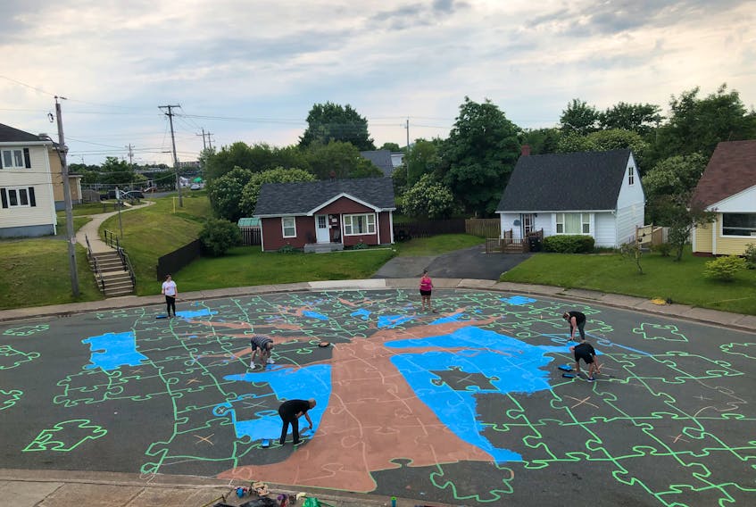 A bird’s eye view of the street art in progress. The painter’s tape will be removed once the design is painted, revealing a puzzle-like image of the tree but also retaining the asphalt texture to ensure a non-slip surface.