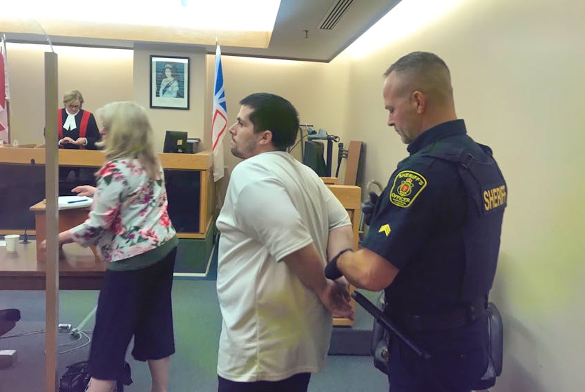A sheriff places handcuffs on 31-year-old Michael Squires before escorting him from a St. John’s courtroom Wednesday afternoon. Squires was sentenced for 37 charges, most of them related to the theft of credit cards from vehicles in residential areas around St. John’s.