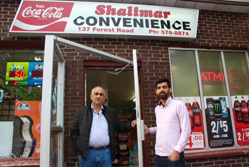 Shalimar Convenience store owner Imran Dar (left) stands outside his business with his son, Irtiza Dar (right). Irtiza was working Wednesday evening when a masked man entered the store, allegedly wielding what Irtiza describes as some kind of steel rod, and demanding cigarettes. – Juanita Mercer/The Telegram