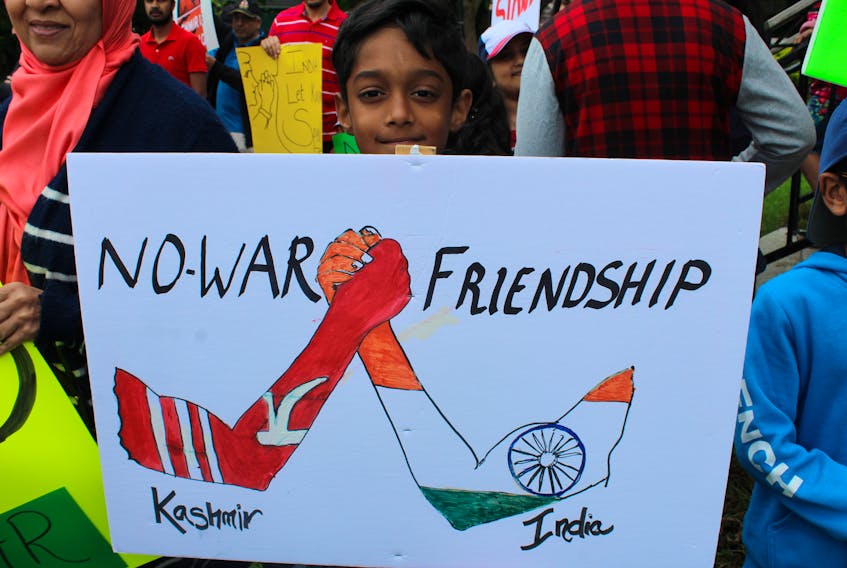 At the Solidarity with Kashmir march, Rayan Sheikh, 9, holds a sign encouraging peace between India and Kashmir.