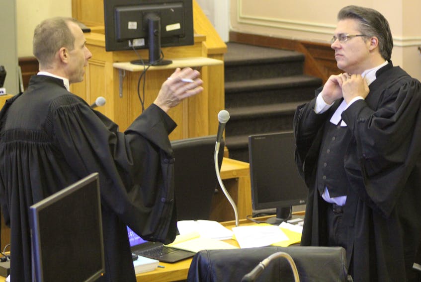 Crown prosecutor Jude Hall (left) and defence lawyer Mark Gruchy discuss an element of the case of a MUN student charged with attempting to murder his friend by pushing him off a cliff on Signal Hill, before the student's trial begins Monday.