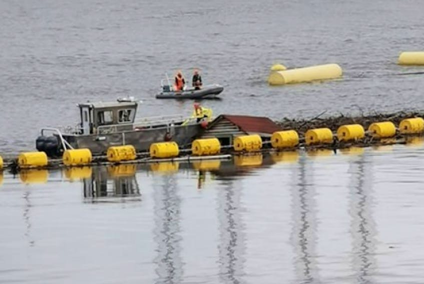 Workers at the Muskrat Falls site retrieve a shack found floating in the reservoir on Monday.