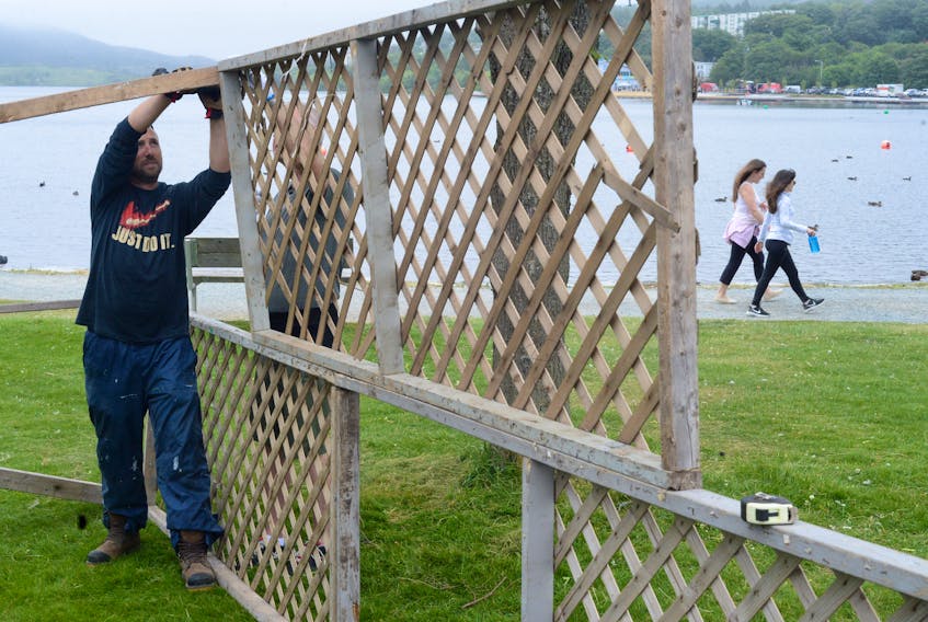 Star of the Sea members Dave Coady (left) and George Campbell set up the club’s “Match The Ticket” game booth Monday at Quidi Vidi Lake in preparation for Regatta Day.