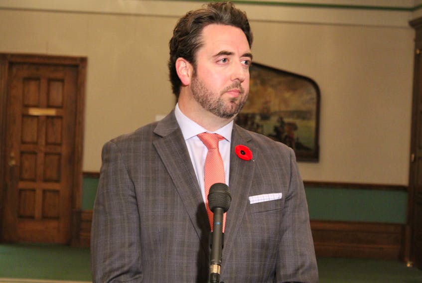 Justice Minister Andrew Parsons speaks with reporters Tuesday outside the House of Assembly.