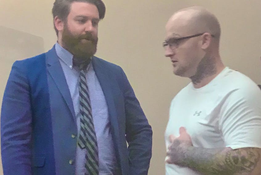 Tim Blake (right) speaks with his lawyer, Tim O’Brien, before sheriffs escort him from a St. John’s courtroom after his trial adjourned for the day Thursday.