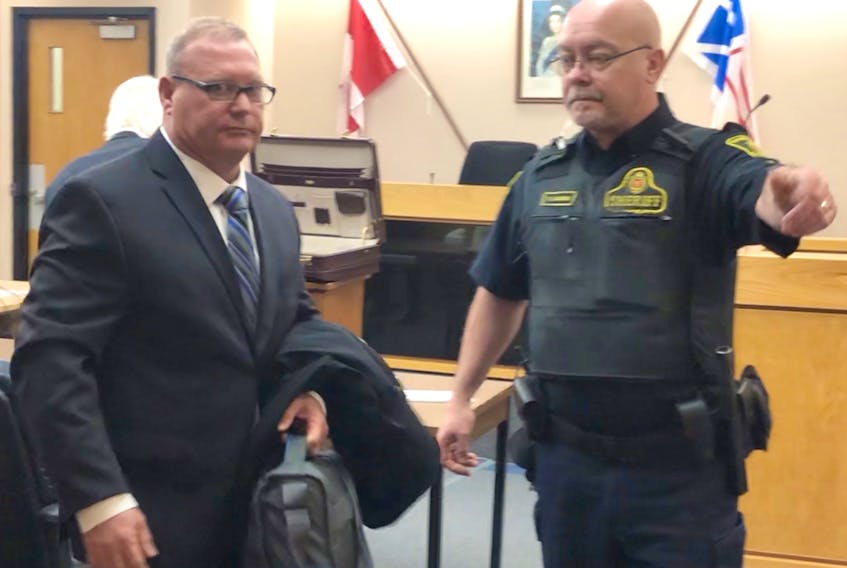 A sheriff directs Barry Bowers (left) from a St. John’s courtroom Tuesday morning to begin a six-month jail term for accessing child pornography.