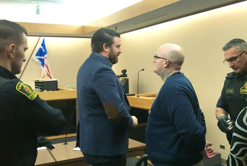 Tim Blake (centre right) speaks to his lawyer, Tim O'Brien, before sheriffs escort him from a provincial courtroom in St. John's Thursday morning. Blake was sentenced to more than two years in prison for a dozen charges, including violent crimes against his ex-girlfriend.