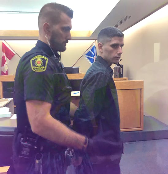 A sheriff prepares to escort Andrew Parsons from a St. John’s courtroom Tuesday after he received the first of two prison sentences for armed robberies.