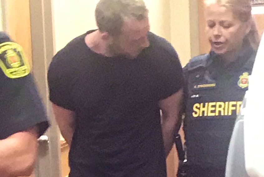Kevin Evans leaves a provincial courtroom in St. John’s with sheriffs Thursday afternoon.