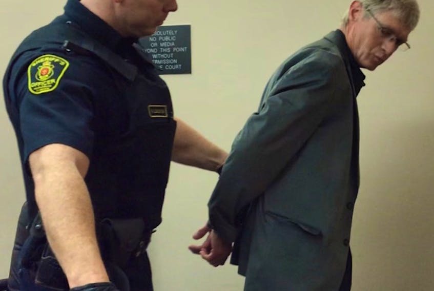 A sheriff escorts Christopher Barnes, 55, to the cells at provincial court in St. John’s Thursday after he pleaded guilty to charges related to the luring of what Barnes had believed was a 15-year-old girl.