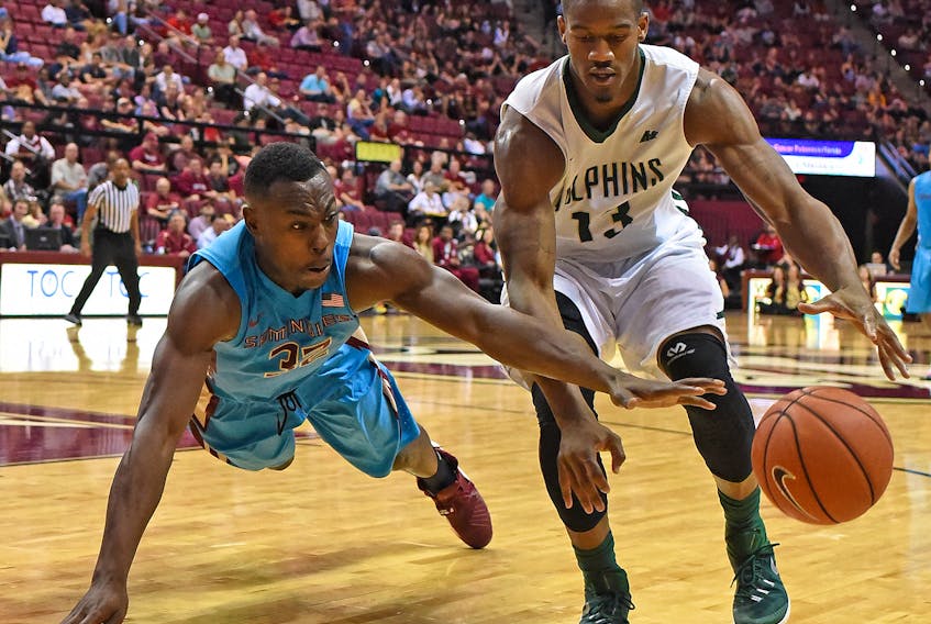 In this Nov. 17, 2015 file photo, Montay Brandon of the Florida State Seminoles dives for the ball in front of Marcel White (13) of the University of Jacksonville Dolphins during NCAA basketball play. Brandon signed with the St. John’s Tuesday, becoming the fourth player on the team’s roster as it prepares for the 2019-20 National Basketball League of Canada season. — Florida State Athletics