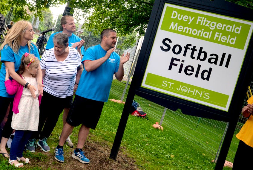 Members of Duey Fitzgerald’s family, from left, his daughter-law Lisa, his granddaughter Avery, his wife Shirley and sons Andrew and Stephen (Lisa’s husband), look on Saturday during the unveiling of the sign that denotes the ballfield at Victoria Park in St. John’s has been renamed in honour of Fitzgerald, who died just over a year ago at 84.