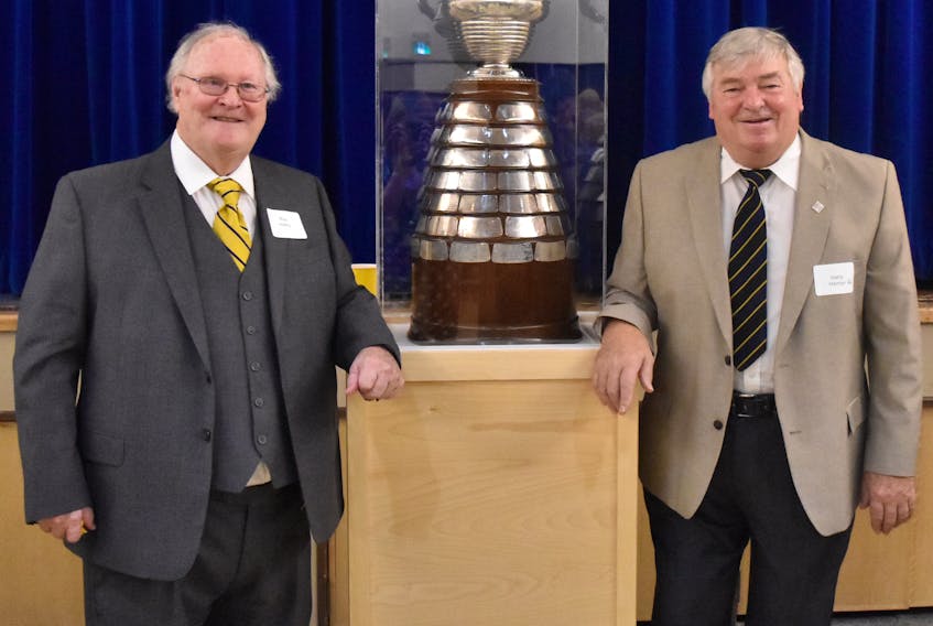Alumni Ray Halley (left) and Harry Hamlyn pose with the Boyle Trophy during a reunion at St. Bonaventure’s College in St. John’s earlier this week. The Boyle Trophy was awarded to the St. John’s senior hockey champions from 1904 to 1971, with St. Bon’s claiming it 27 times, far more than any other team. That included a 16-year run that began 75 years ago, in 1944. Hamlyn was part of the Blue and Gold’s entry that took the trophy in 1959, while Halley won the Boyle Trophy as a player with the 1965 Memorial University side. — Submitted photo/Krista Cardwell