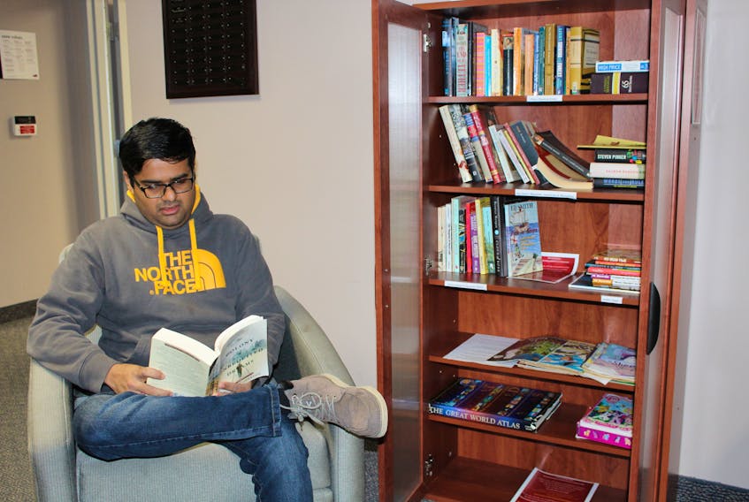 Killol Chokshi takes time from a busy morning to read a few pages of a book that he secured from the Book Box, an initiative he helped to found at Memorial University in St. John’s. The project is designed to give students, staff and even their children a place to go to relax and enjoy reading from a host of selections that will be publicly available in the hallway between the Research Grants and Graduate Students offices in the Bruneau Centre.