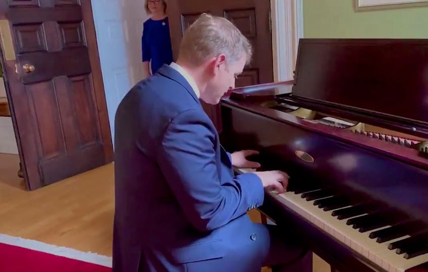 Premier Andrew Furey plays the piano as Lt. Gov. Judy Foote is about to enter the room during a break in the official proceedings at Government House in St. John's on Wednesday. — Twitter
