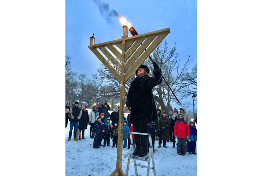 Lt.-Gov. Judy Foote lights the shamash candle of the Hanukkah menorah at Bannerman Park in St. John’s Sunday during a ceremony to celebrate the first day of the Jewish holiday.