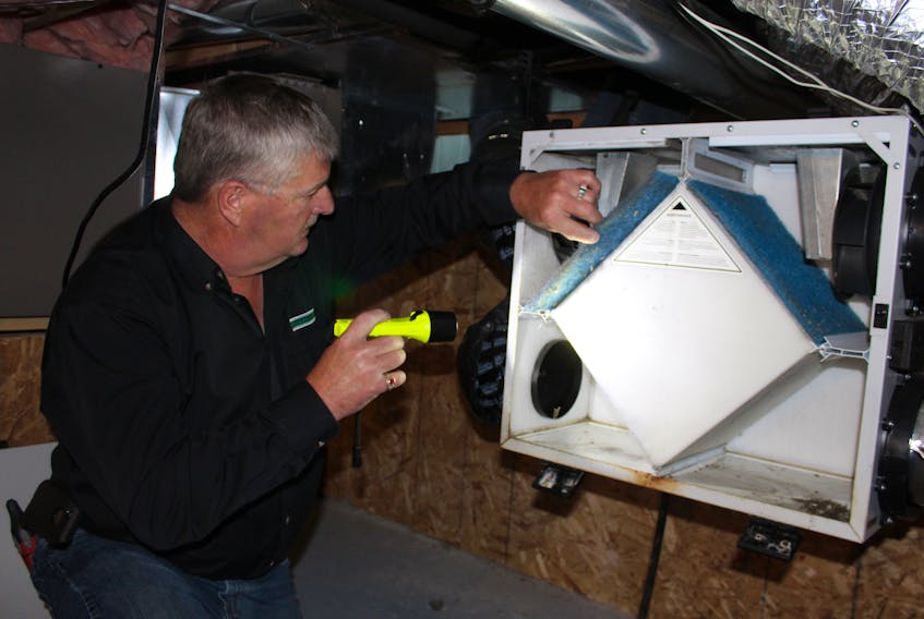 Fred Holwell of HouseMaster Home Inspection, looks over a Venmar system in a home earlier this week.