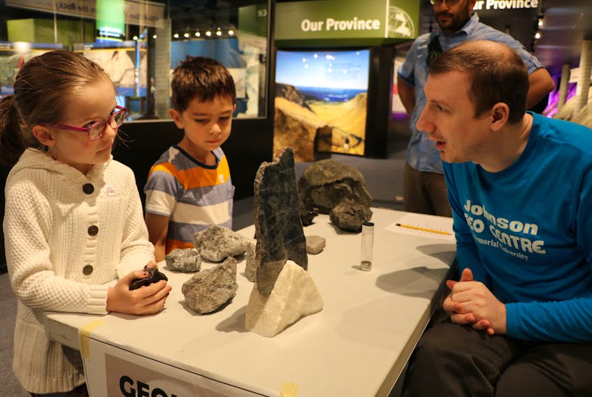 Alice Tucker, 6, and Eric Pant, 6, learn about the geology of the moon from Johnson Geo Centre science interpreter Donald Raeside Saturday during the Apollo 50th moon landing anniversary event.