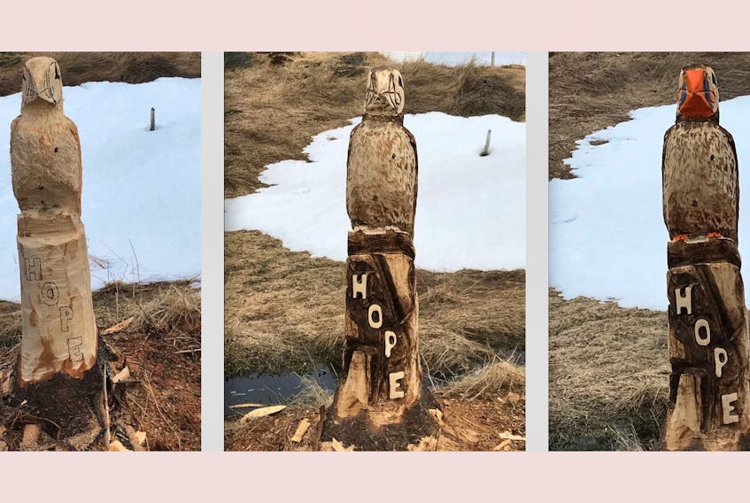 Progress is made on a carving of a puffin, emblazoned with the word “Hope,” earlier this month along a trail near Renews. — Contributed