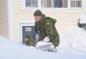Pte. Roman Crummey, left, and Cpl. Pat Breen of the Royal Newfoundland Regiment were hard at work digging out the front door of a basement apartment on Franklyn Avenue in St John's Monday. — ANDREW ROBINSON/THE TELEGRAM