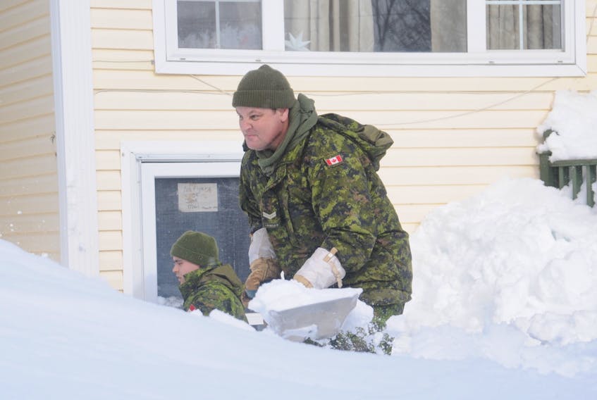 Pte. Roman Crummey, left, and Cpl. Pat Breen of the Royal Newfoundland Regiment were hard at work digging out the front door of a basement apartment on Franklyn Avenue in St John's Monday. — ANDREW ROBINSON/THE TELEGRAM