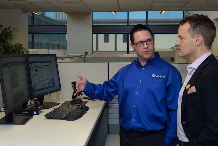 Tommy Harris, a business analyst with Quorum Information Technologies Inc., discusses the company's XSellerator software platform with Indigenous Services Minister Seamus O’Regan at the company's offices in St. John's Tuesday.