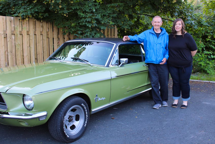Harry (Herk) Phillips and his granddaughter, Stephanie Mealey, pose with a 1968 Mustang, one of a host of vintage cars that are located across Newfoundland and Labrador.