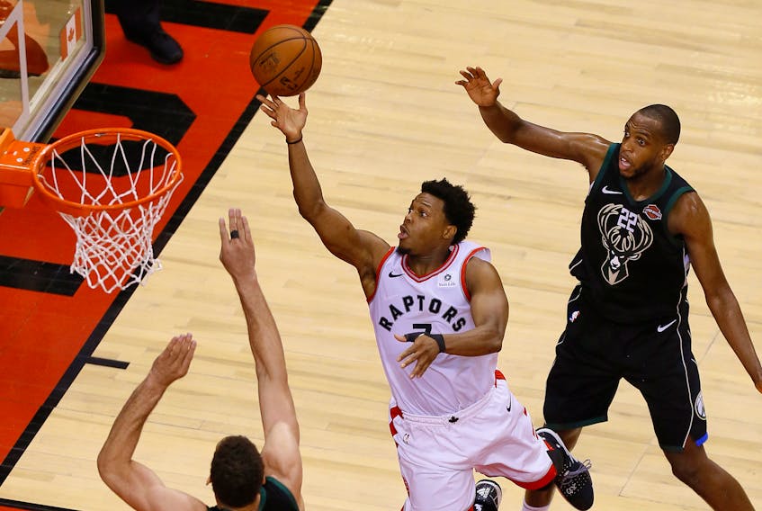 Toronto Raptors guard Kyle Lowry goes up to make a basket as Milwaukee Bucks center Brook Lopez (11) and Bucks forward Khris Middleton look on during game six of the Eastern conference finals. - John E. Sokolowski/USA TODAY Sports