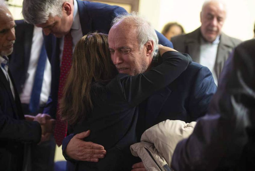 Dr. Masoud Adibi is comforted following a memorial service on Thursday night at the Al Rasoul Islamic Society in Bedford for the victims of the Ukraine International Airlines plane crash in Iran. Adibi is the husband of Dr. Sharieh Faghihi, a Halifax dentist who was one of five Nova Scotians killed in the crash.