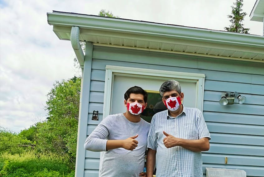 Samy and Ammar Hudhud pose for a photo at their home in Nova Scotia, where they moved in fall 2019. Leading up to Canada Day, the son and father duo crafted a couple hundred masks featuring Canada Day flags for people all over Canada to keep them safe and protected amid the COVID-19 pandemic.