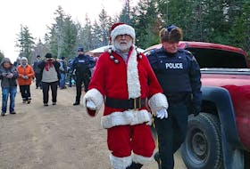 A protester dressed as Santa Claus is led away by the RCMP during the arrest of nine forestry operation blockaders Tuesday afternoon in Digby County.