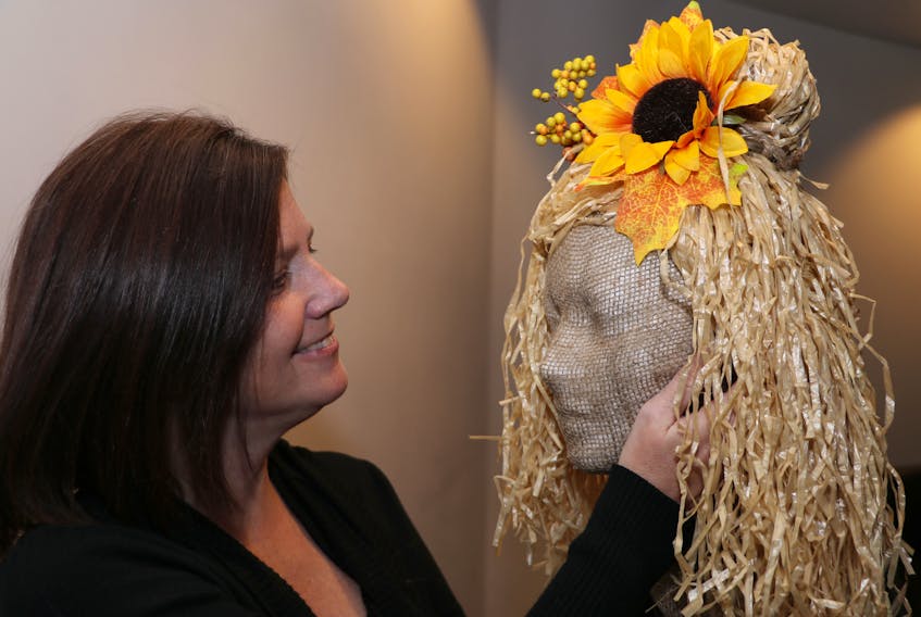 Cheryl Laliberté, the Town of Amherst's well-being manager, begins decorating the head of a scarecrow that will be part of the Scarecrow Stroll during the month of October. Tom McCoag / Town of Amherst