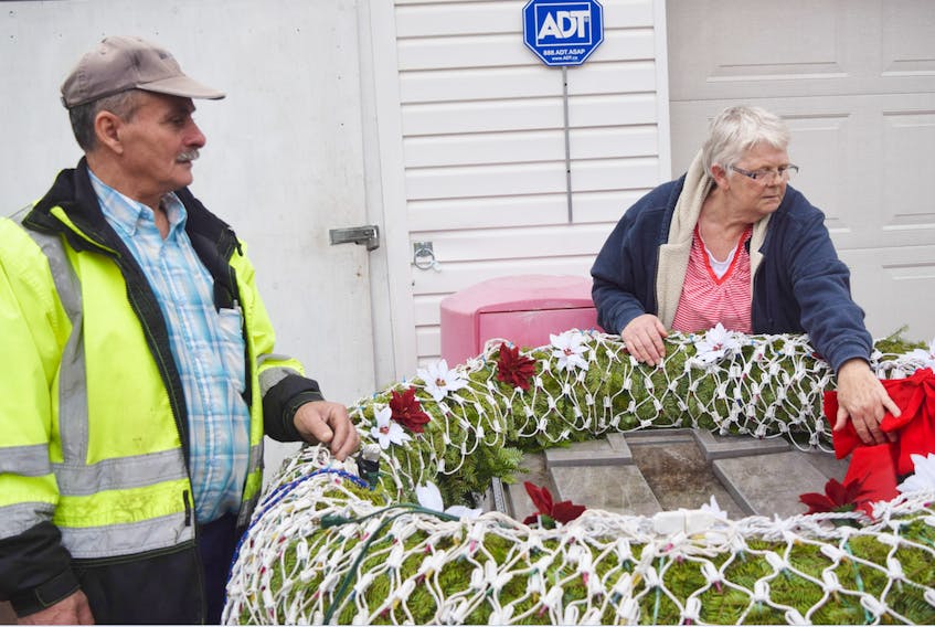 Pedro and Margie Barreto put the finishing touches on a wreath they plan to light up, as part of their Christmas display at 50 Veterans Drive in Pictou.