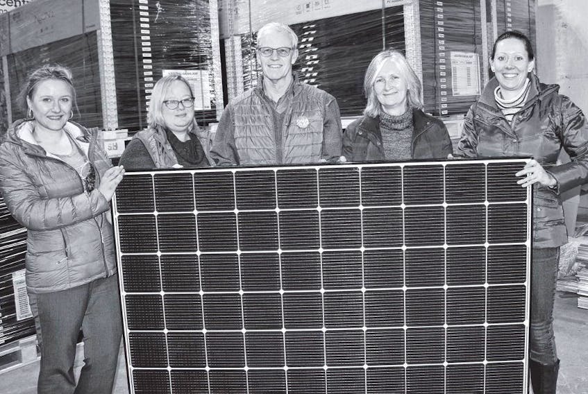 Nova Solar Capital employees Agnes Wojt and Dawn Davison, co-founders Andrew Bagley and Christine Heap, and employee Amanda Brule hold a solar panel in the company’s warehouse. IAN FAIRCLOUGH • THE CHRONICLE HERALD