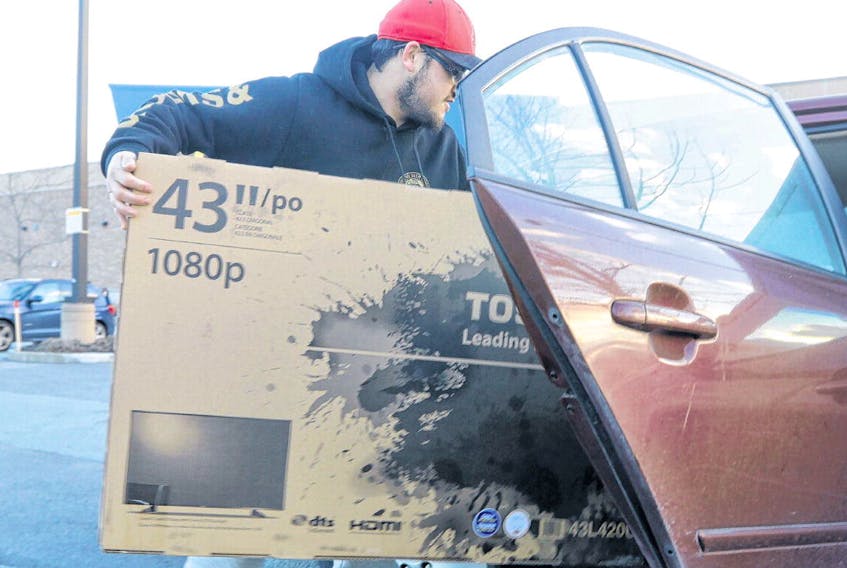 Evan White loads his new 43-inch television into his car on Tuesday, after taking advantage of a Boxing Day Sale at Best Buy in Dartmouth Crossing Wednesday.
ERIC WYNNE • THE CHRONICLE HERALD