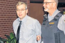 Leslie Greenwood is led into Supreme Court in Kentville Wednesday for his trial on two charges of first-degree murder in the deaths of Barry Mersereau and Nancy Christensen in September 2000.