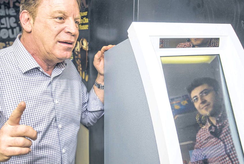 Coin Nation ATMs CEO Stephen Offman talks about Bitcoins as Akram Ayach, head of operations, is reflected in the screen of their company’s cryptocurrency ATM at the Daily Sweets Kwik-Way on Oxford St. on Tuesday. RYAN TAPLIN • THE CHRONICLE HERALD