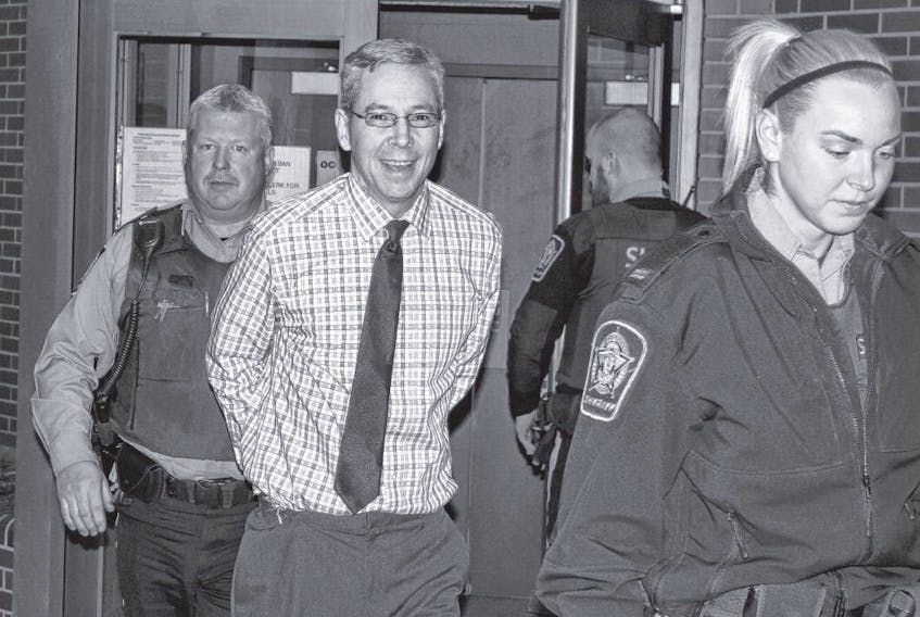 Leslie Greenwood smiles as he is led from Nova Scotia Supreme Court in Kentville Wednesday. He is charged with two counts of first-degree murder in the deaths of Barry Mersereau and Nancy Christensen in September 2000.