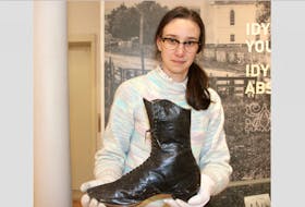 Margaret Mulrooney, curator at the Colchester Historeum, holds a boot that was worn by Anna Swan. The boot, approximately size 16, is currently on display, for the first time ever, at the historeum.