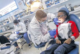 Ari Oba, 10, shows off his teeth to dentistry hygenist student Boyd Roul at the Dal dentristy clinic at Harbourview Elementary in Dartmouth, Friday. TIM KROCHAK • THE CHRONICLE HERALD