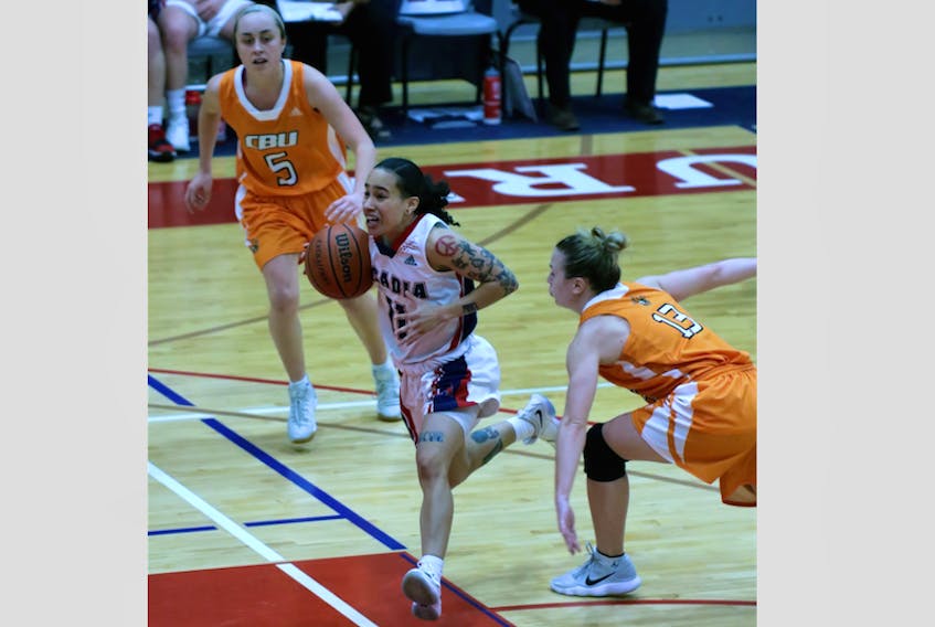 Paloma Anderson, centre, rushes the net for the Axewomen. Anderson contributed a game-high 20 points.