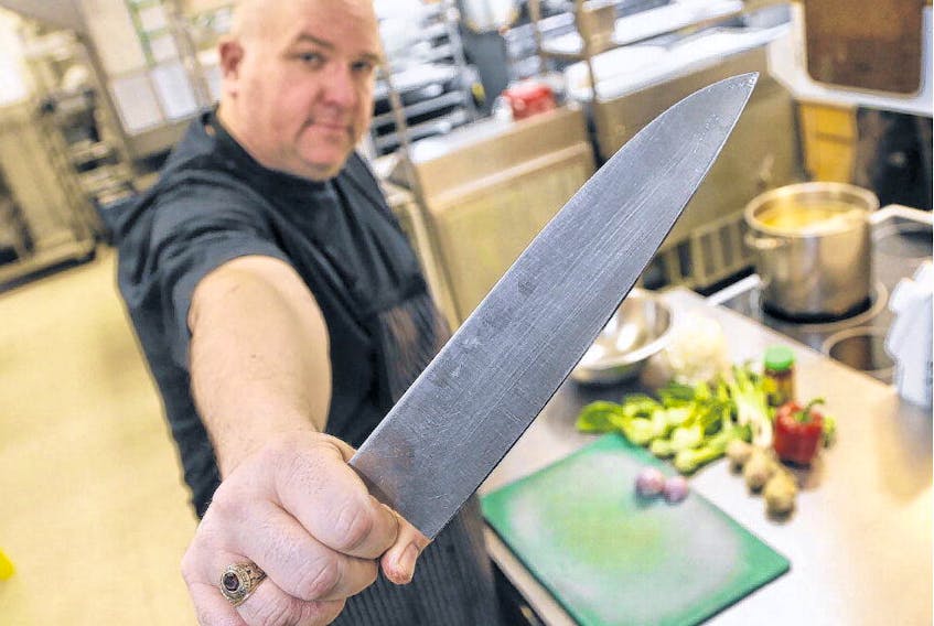 Craig Flinn displays a chef's knife, a Maestro Wu, made from the metal of a Second World War propaganda bomb, as seen in his kitchen at Chives in Halifax on Wednesday. TIM KROCHAK • THE CHRONICLE HERALD
