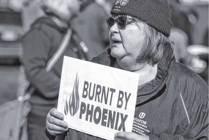 Joyclin Coates, a Unifor retiree, holds a Burnt by Phoenix sign at a Public Service Alliance of Canada rally at HMC Dockyard on Wednesday afternoon. Coates was at the rally to support workers affected by the beleaguered Phoenix pay system.
RYAN TAPLIN • THE CHRONICLE HERALD