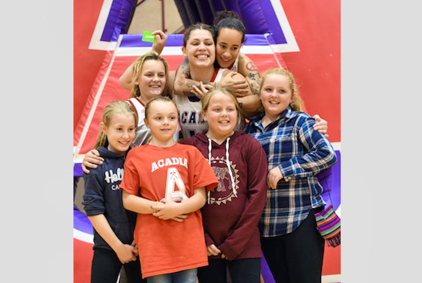 Axewoman Allie Berry, centre, has some fun with teammate Paloma Anderson and some young fans. (PETER OLESKEVICH)